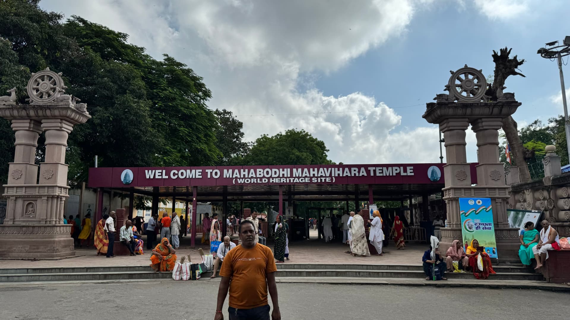 Visitors approach the gateway welcoming pilgrims to the Mahabodhi Temple. — Bodh Gaya, Bihar, India.