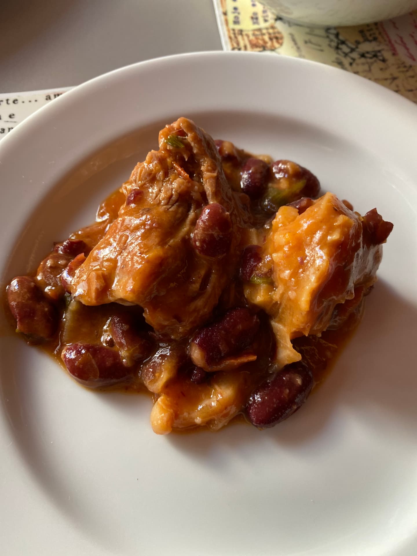 A plate of dark red meat and bean stew