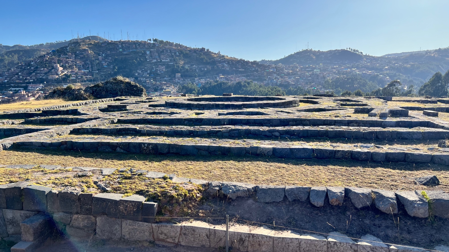 Layered stone terraces at Sacsayhuamán with mountains beyond