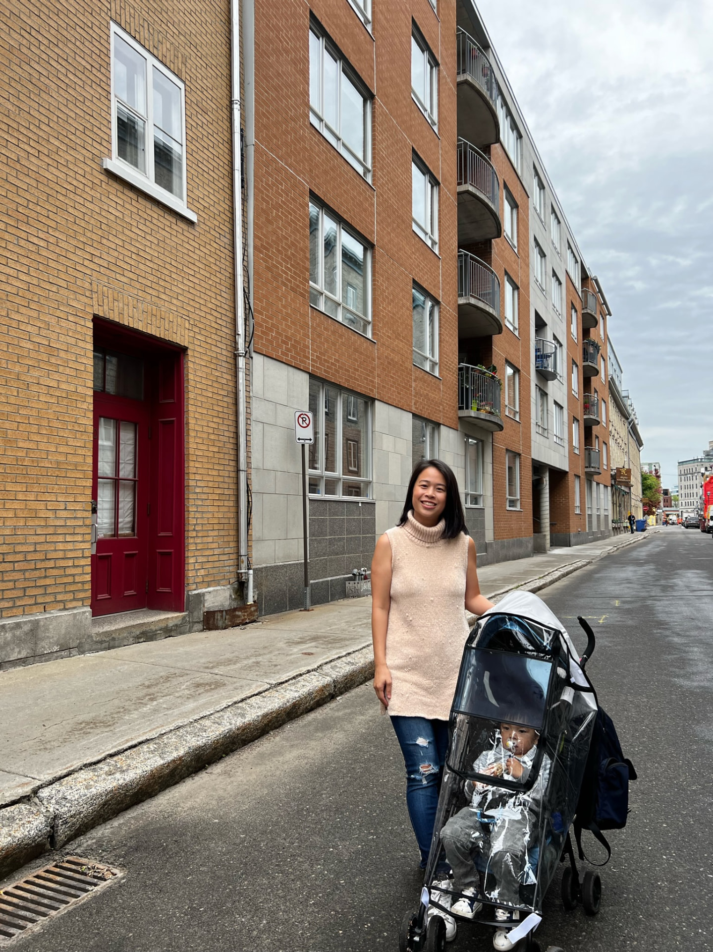 Woman walking beside a stroller on a quiet Québec City street