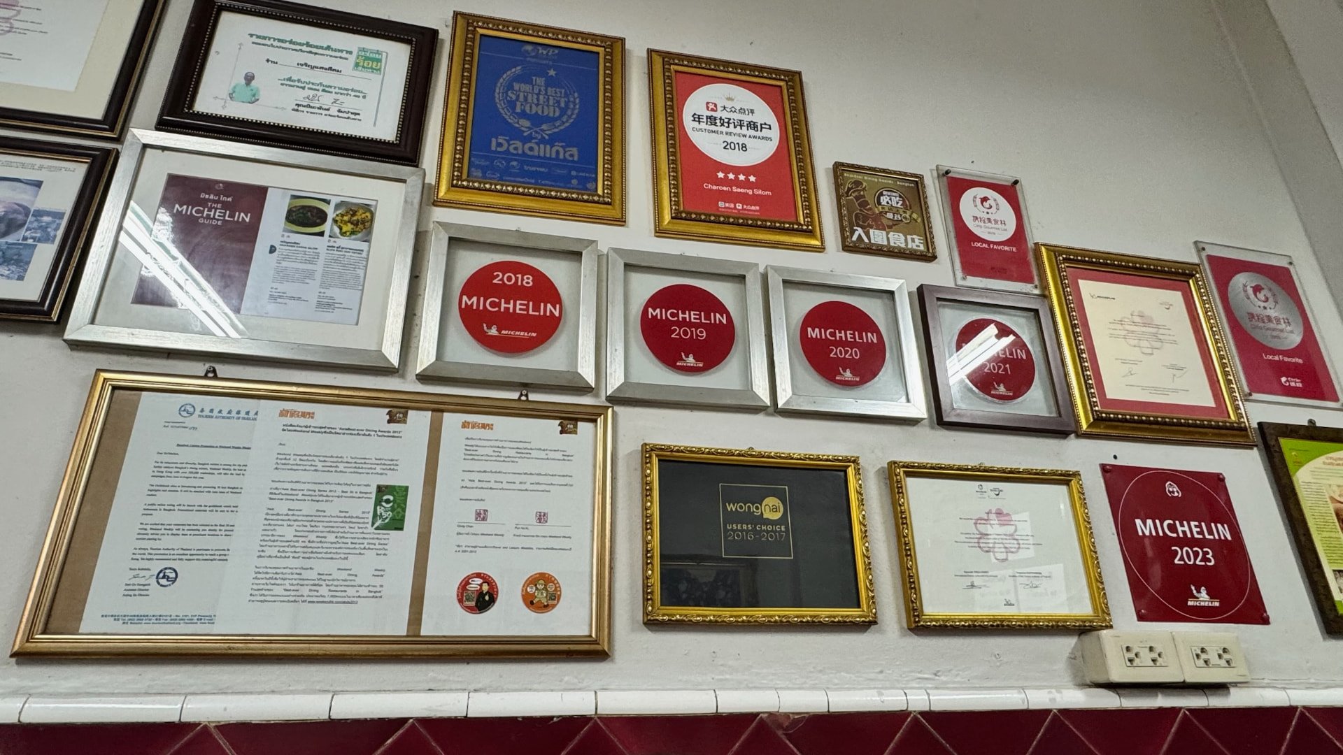 Wall of Michelin and local food awards inside a Bangkok restaurant
