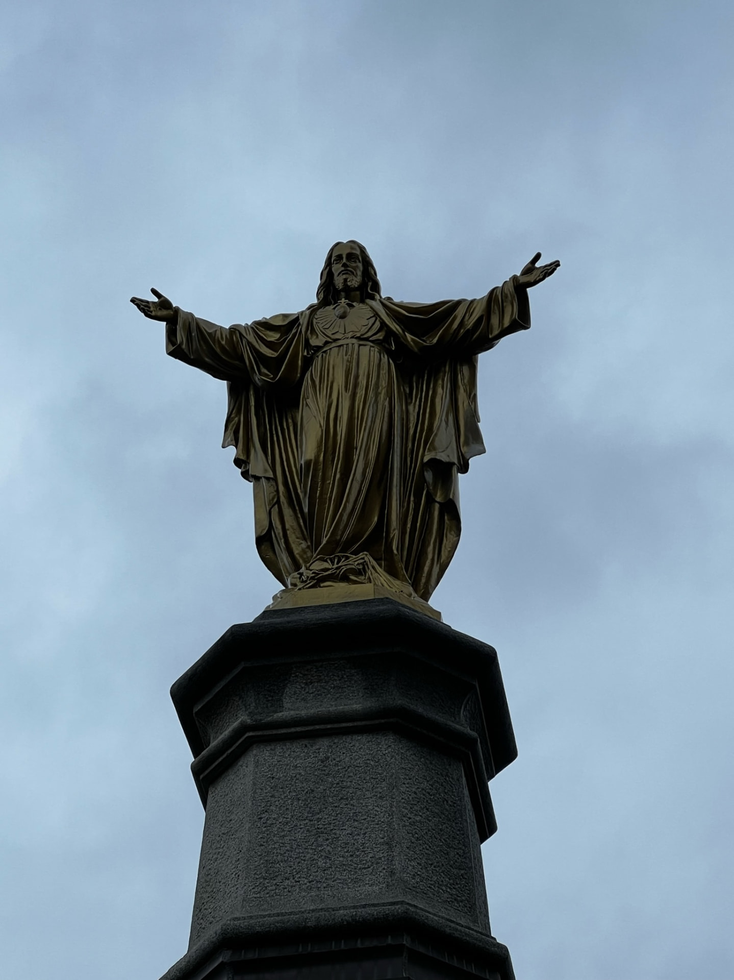 Statue of Christ against an overcast Québec sky