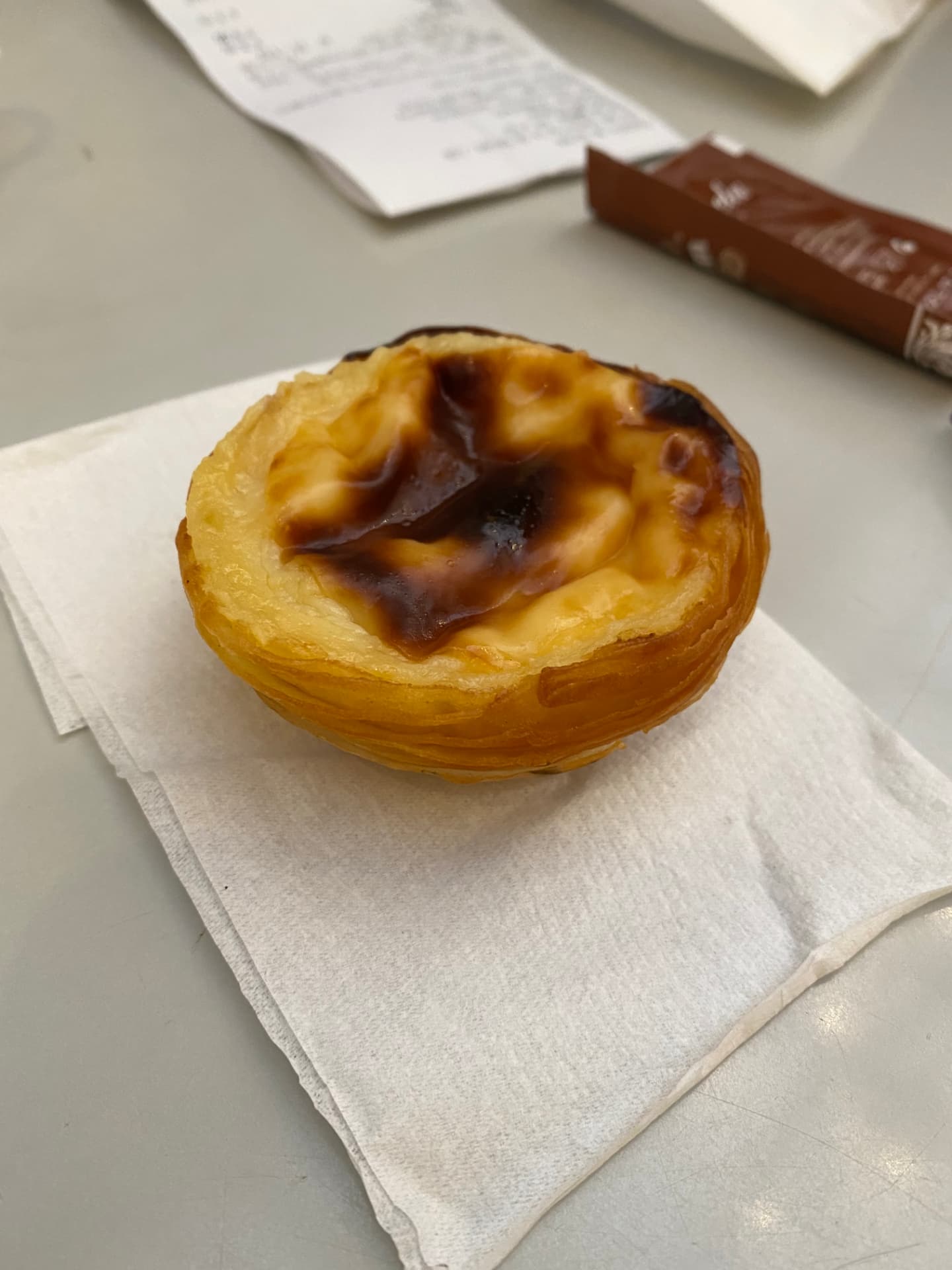 A single pastel de nata resting on a white napkin
