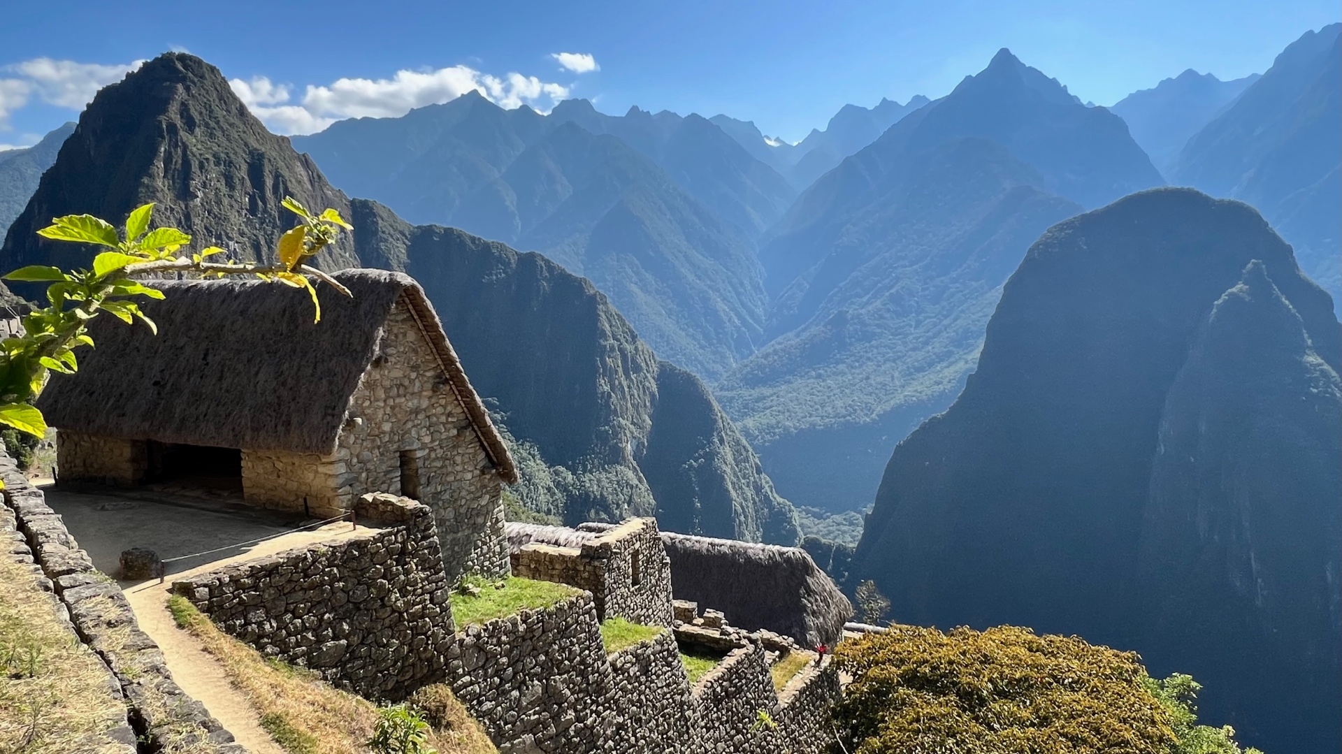 Stone buildings and terraces at Machu Picchu against layered Andean peaks