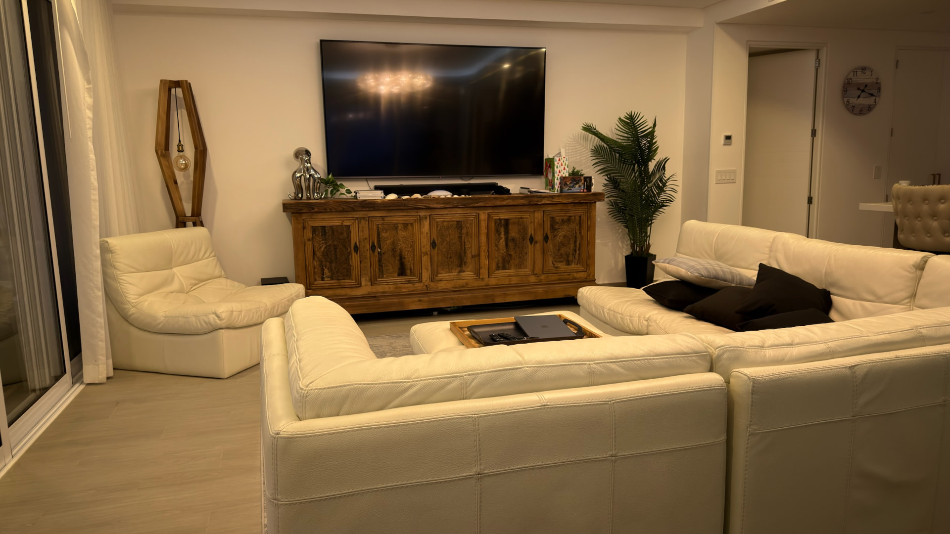 Warmly lit living room with white leather seating