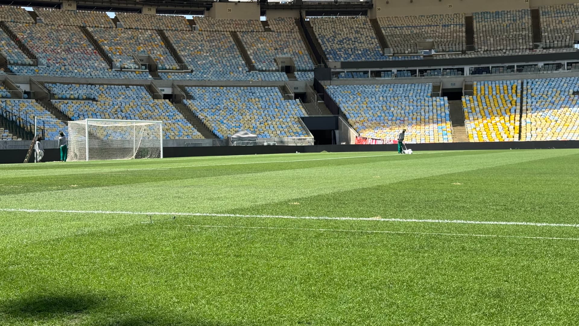 The green Maracanã pitch and empty blue and yellow stands