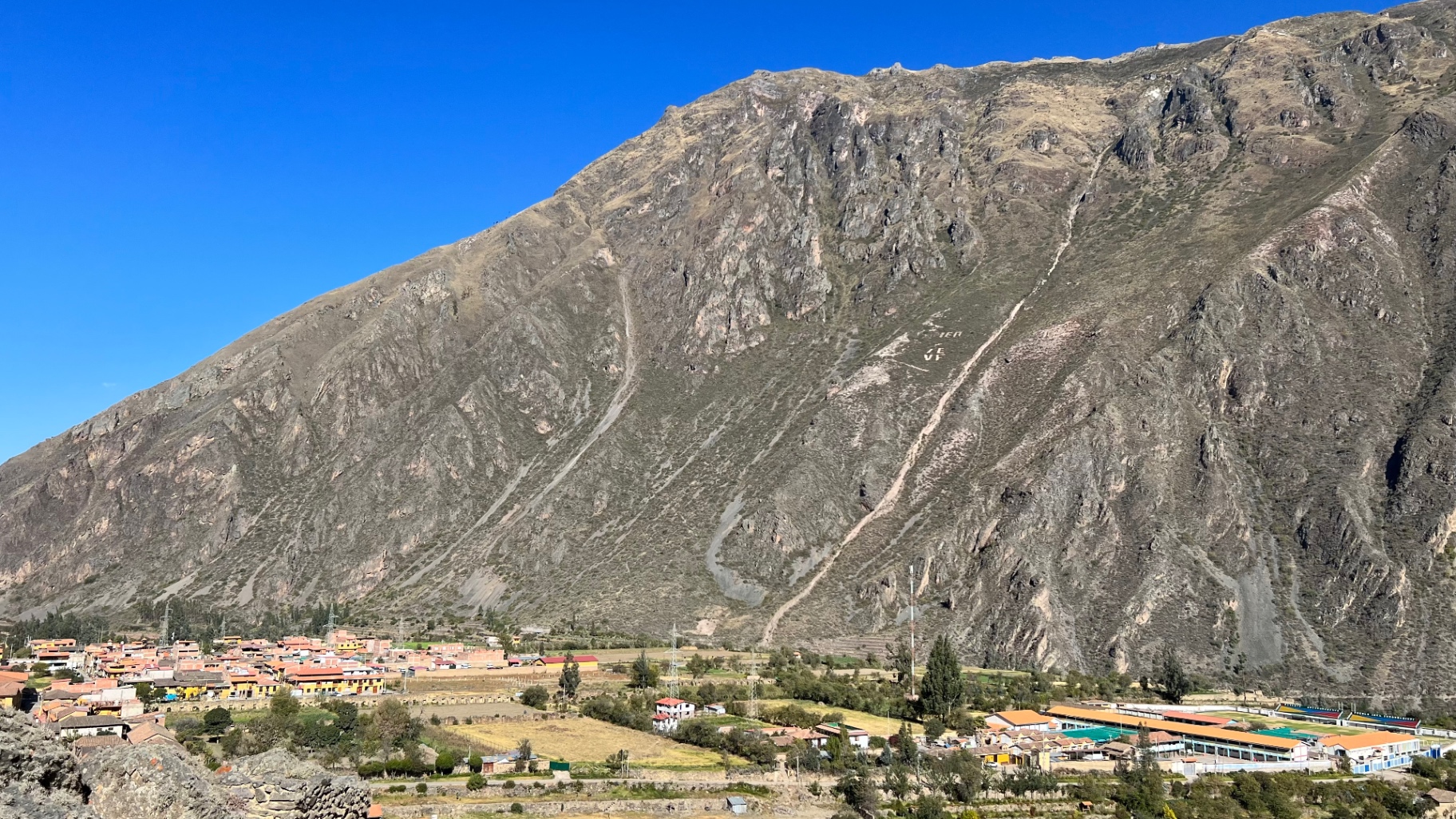Steep rock mountain rising behind the town of Ollantaytambo