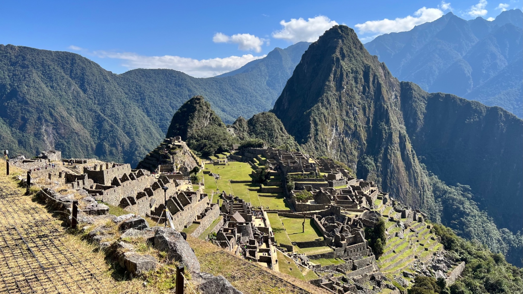 Wide elevated view over the stone buildings, lawns, and terraces of Machu Picchu