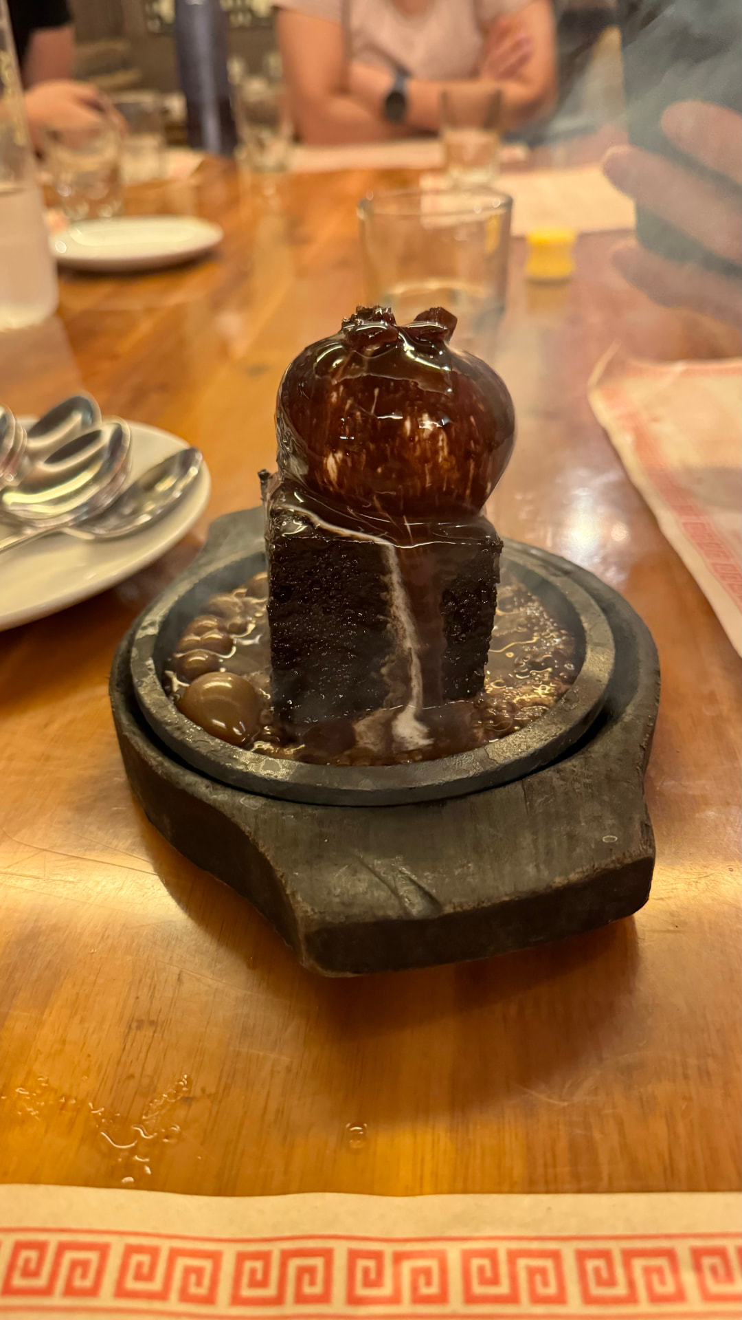 A sauce-covered dish presented on a sizzling serving plate. — Varanasi, Uttar Pradesh, India.