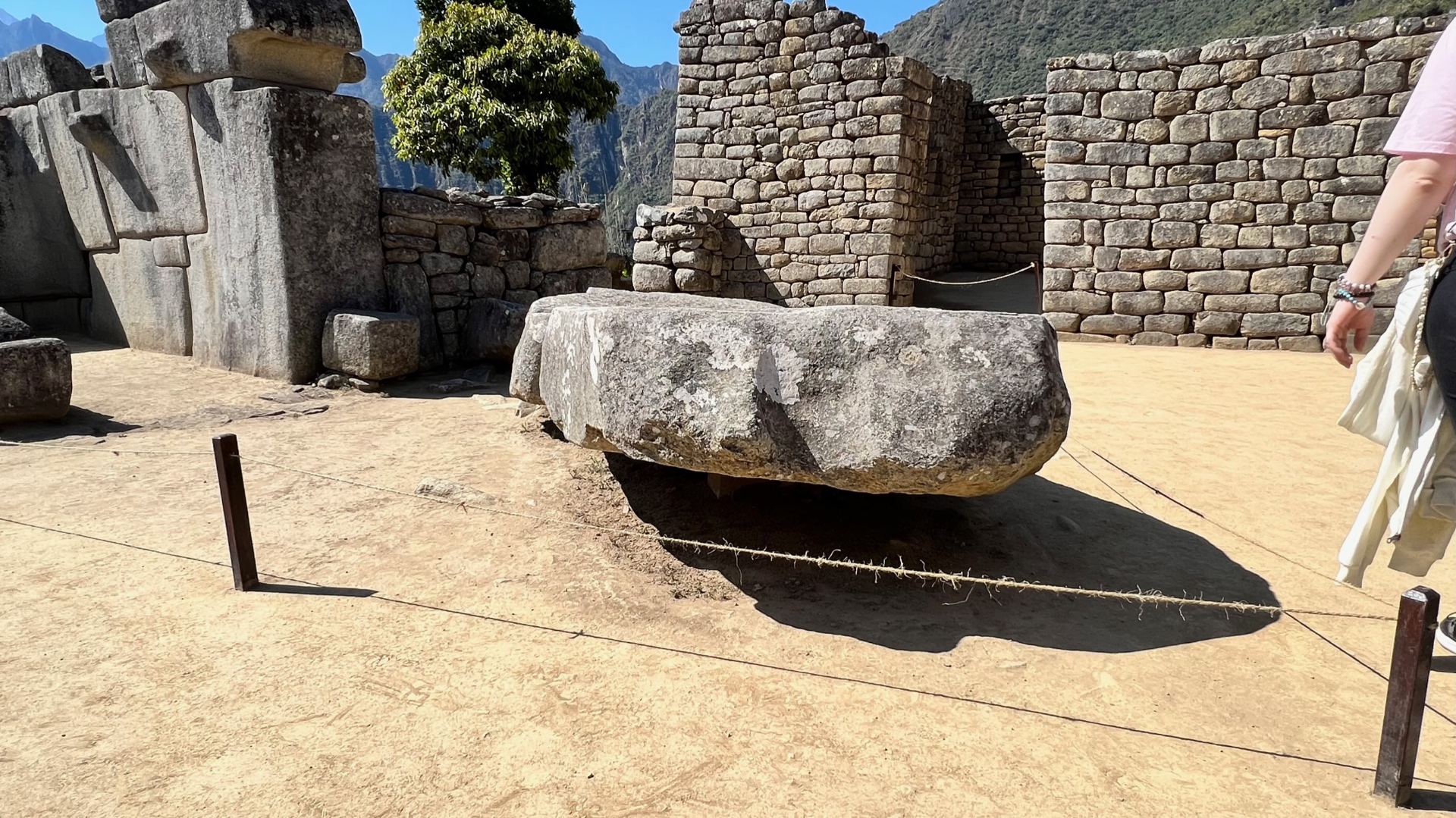 Large ceremonial stone resting within a roped courtyard at Machu Picchu