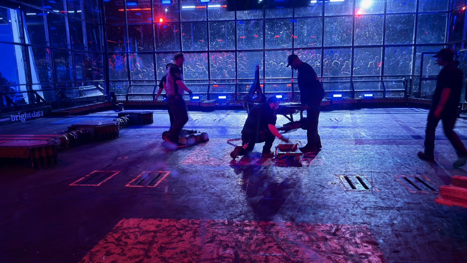 Crew clearing debris from the arena floor between matches