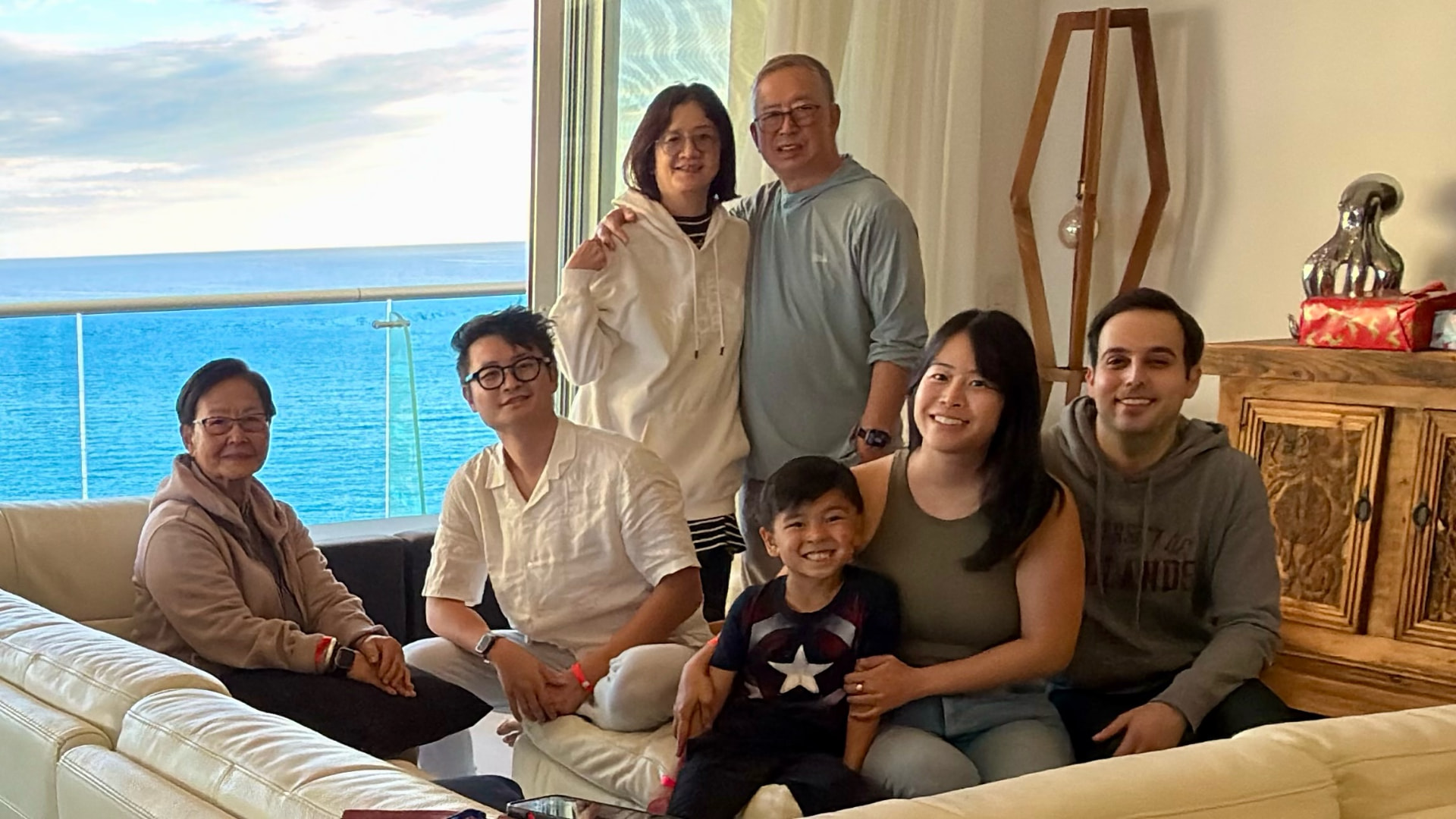Seven family members gathered in an oceanfront living room