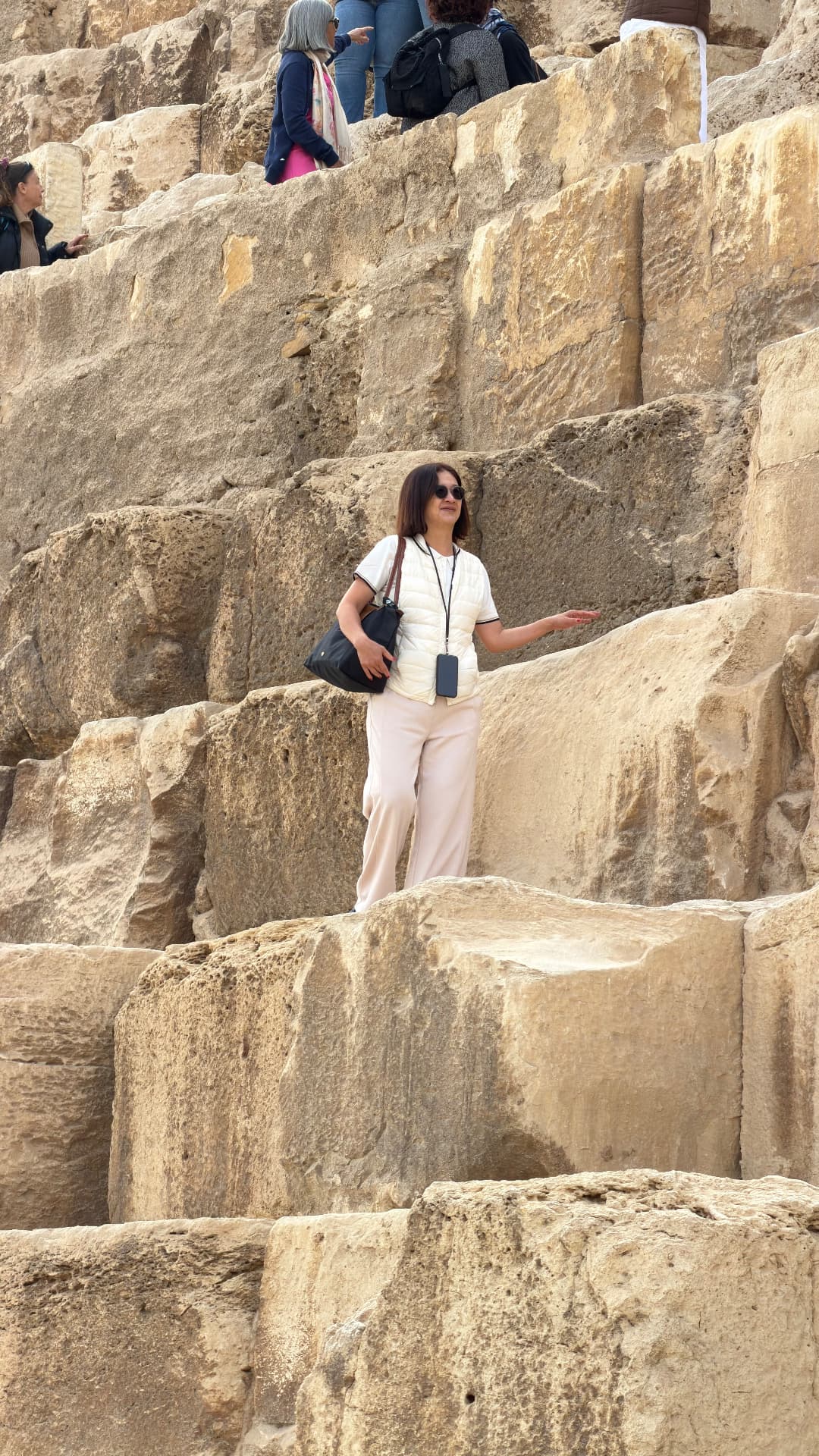 Becky standing partway up the huge stepped blocks of a pyramid