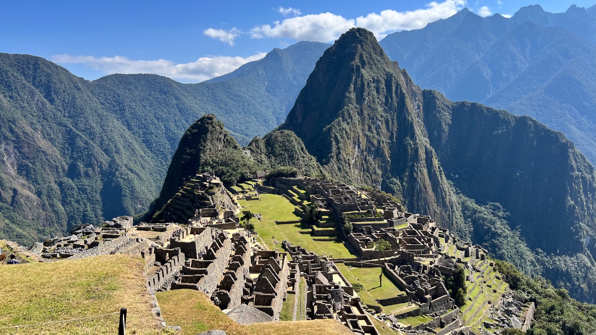 Panorama of Machu Picchu's central lawns, stone buildings, and Huayna Picchu