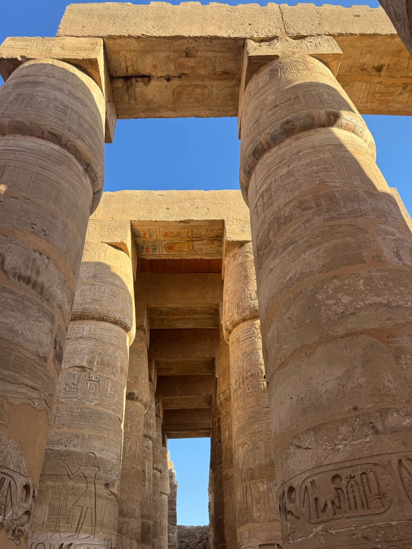 Two great columns at Karnak framing a painted architrave and a strip of blue sky
