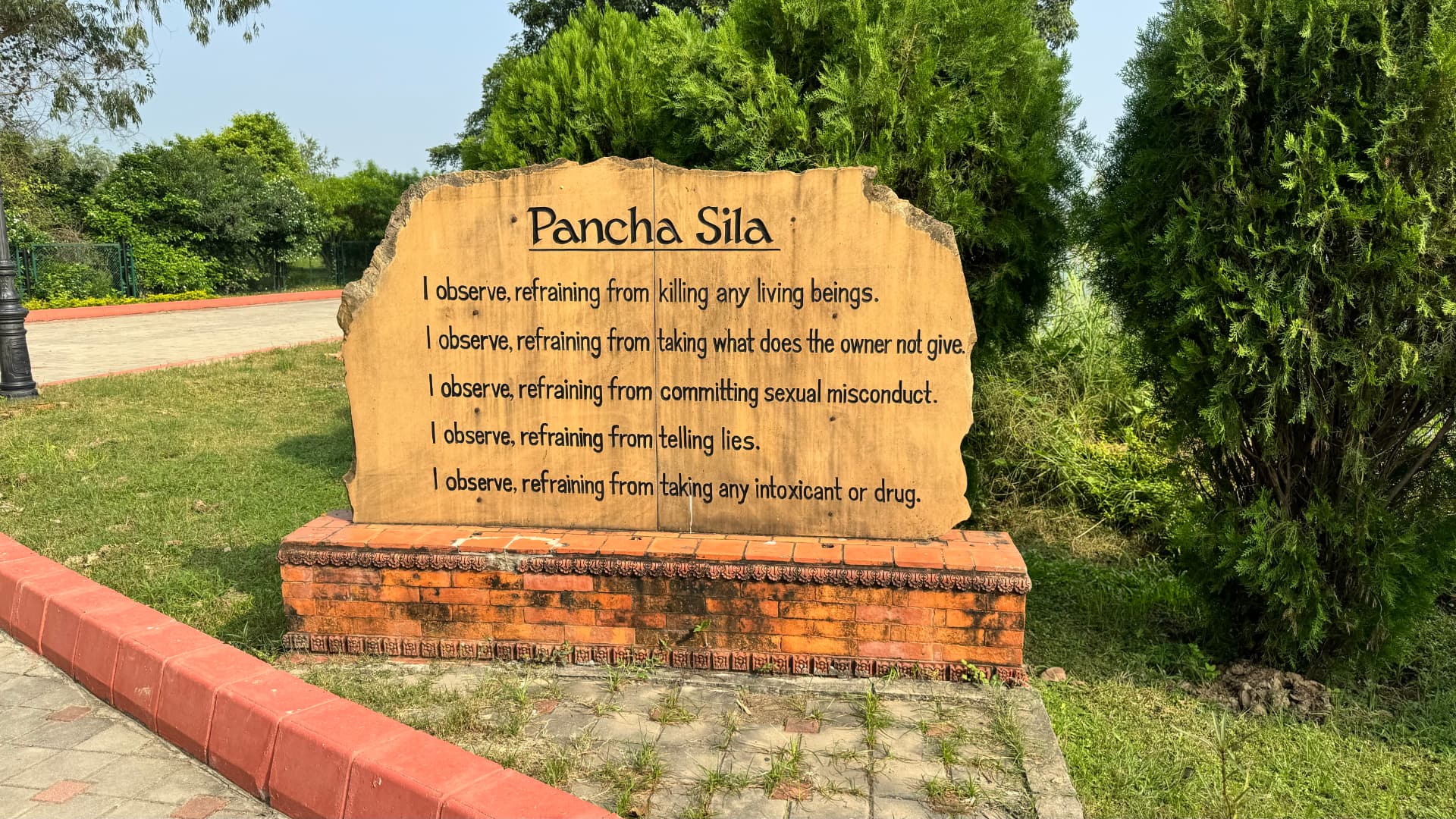 The Pancha Sila stone presents the five Buddhist precepts in the garden. — Lumbini, Nepal.