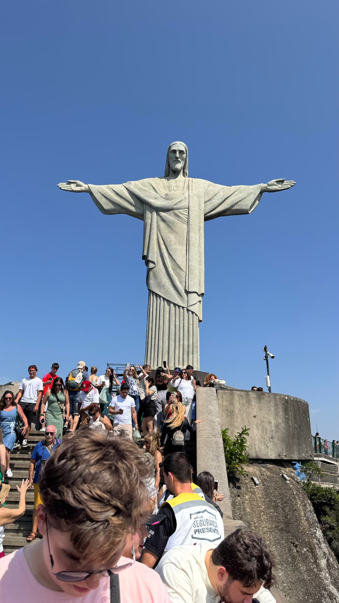 Christ the Redeemer rising above visitors descending the summit steps