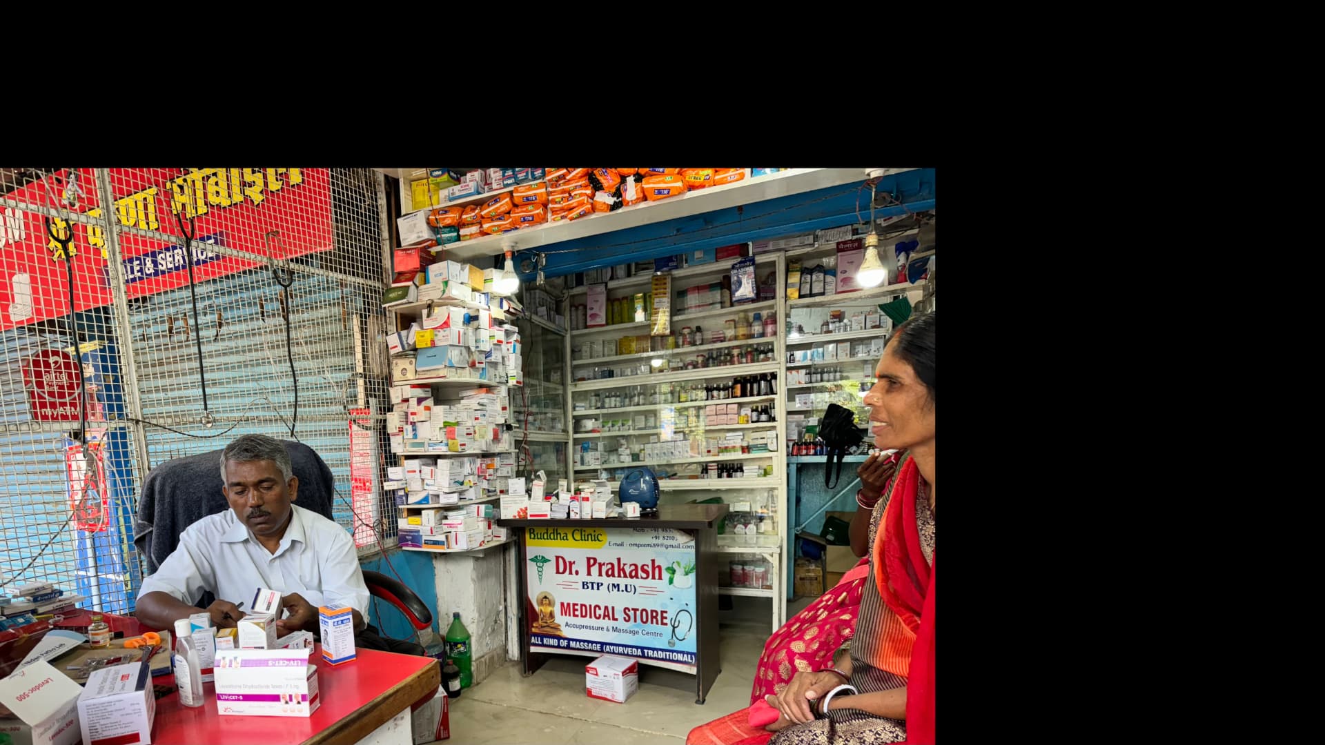 A stop at a small stall filled with colourful religious souvenirs. — Bodh Gaya, Bihar, India.