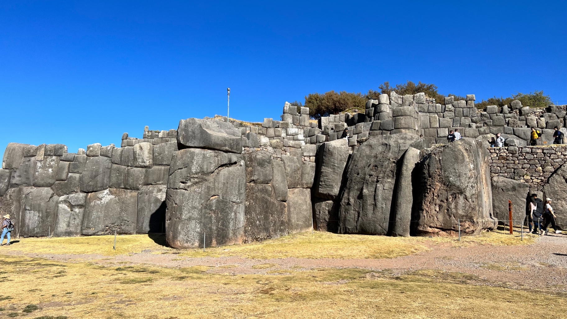 Monumental zigzag stone walls at Sacsayhuamán beneath a blue sky