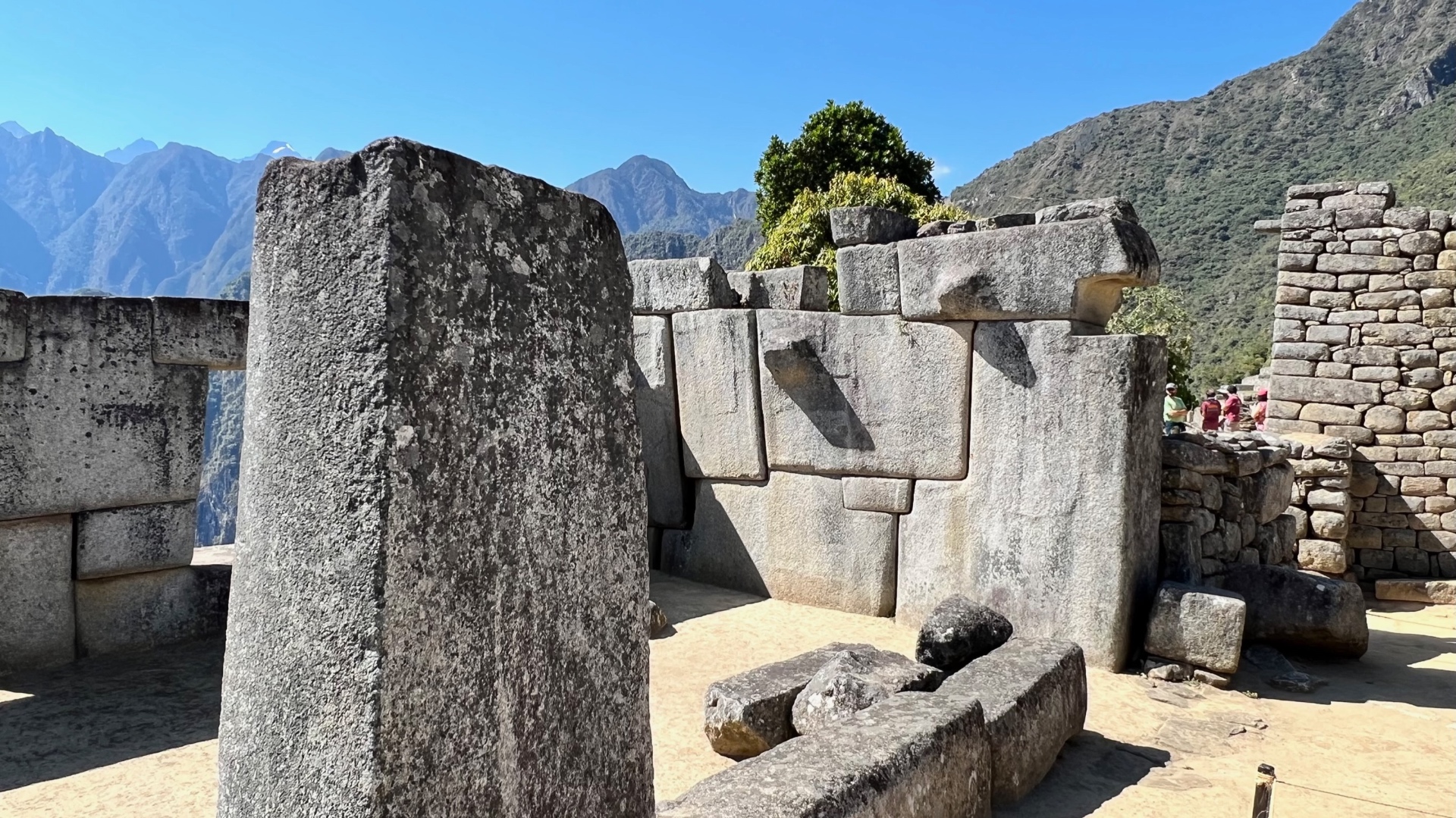 Sacred stone structures framed by distant green Andean peaks