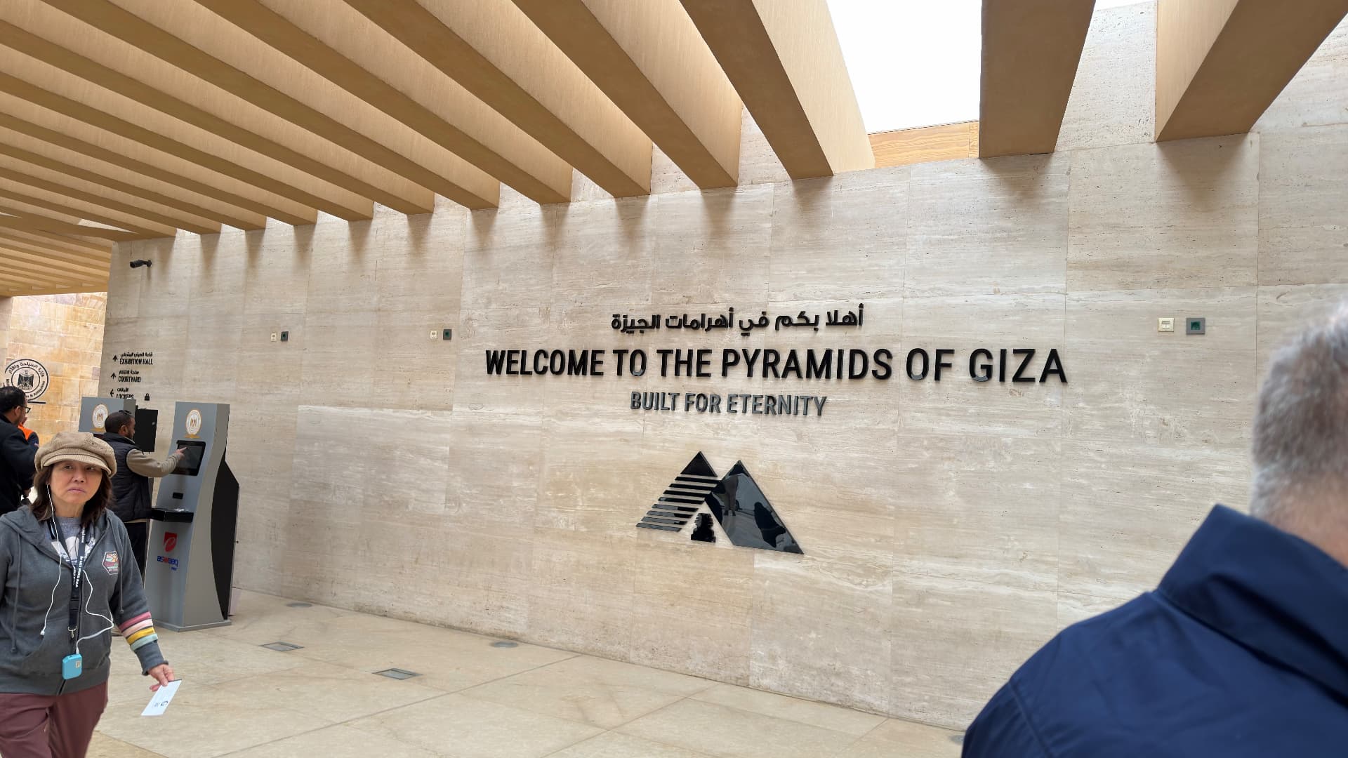 A stone wall at the Giza visitor centre reading Welcome to the Pyramids of Giza, Built for Eternity