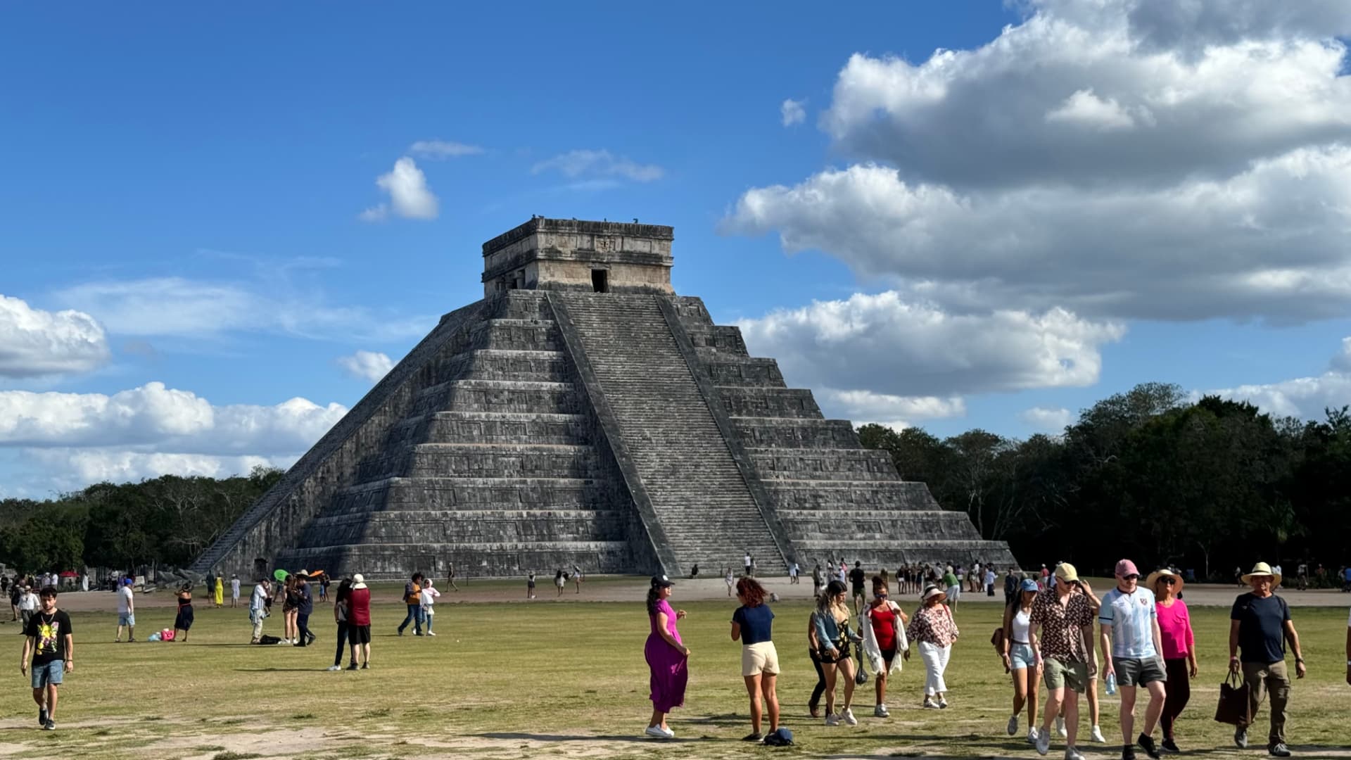 El Castillo rising above the open plaza beneath a blue sky