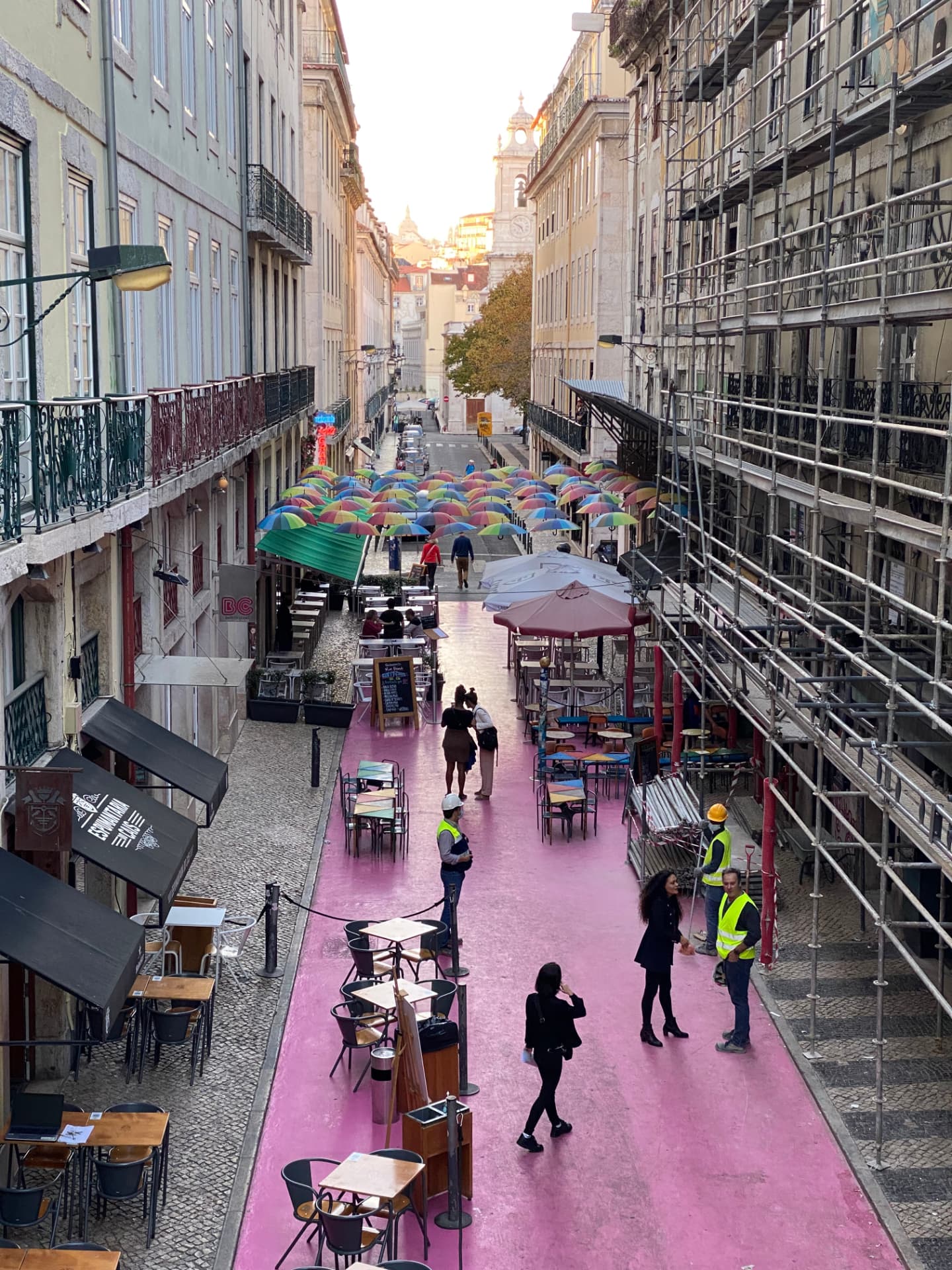 A narrow Lisbon street with pink pavement seen from above