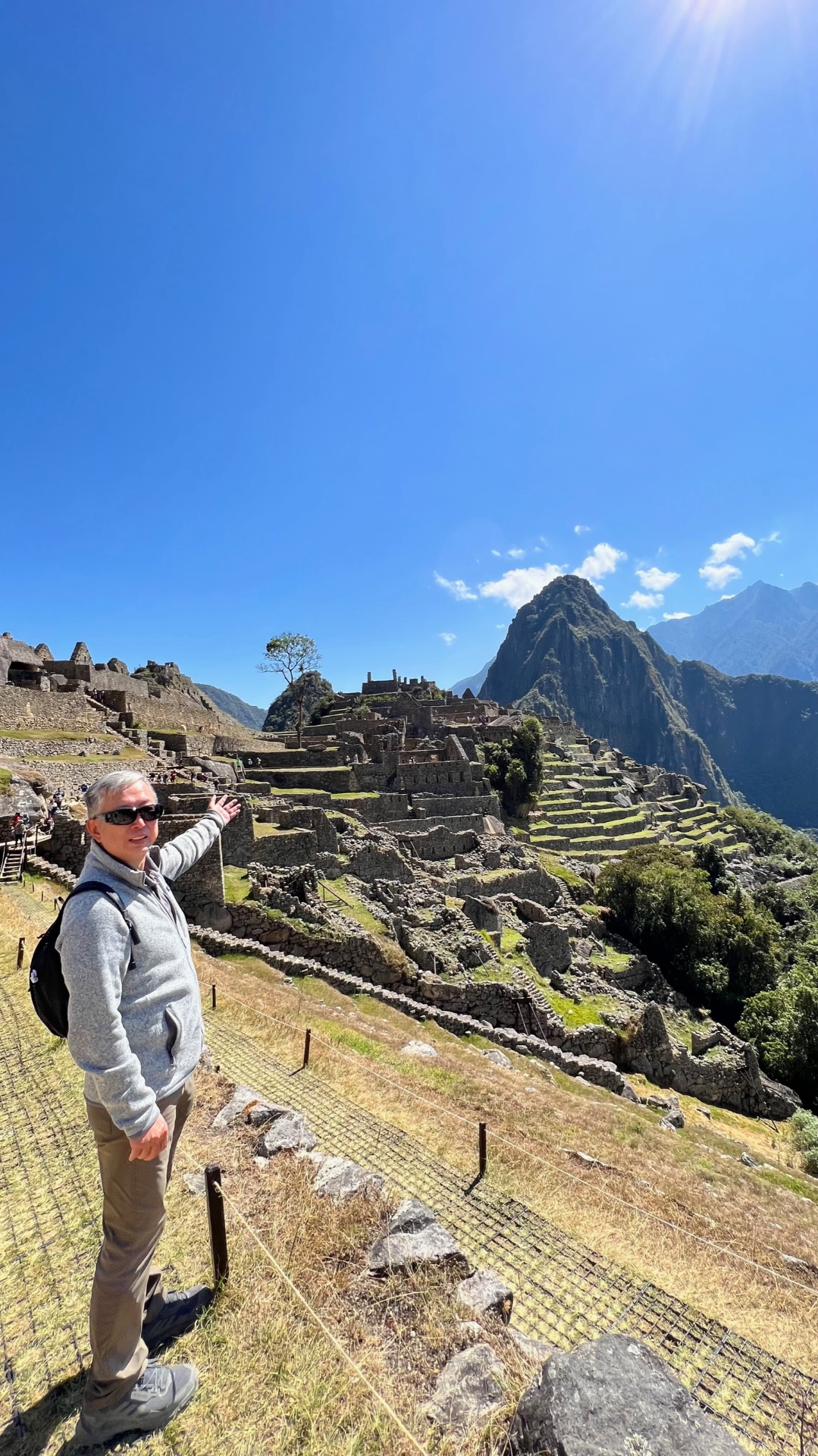 Ken presenting the panoramic view of Machu Picchu beneath the high sun
