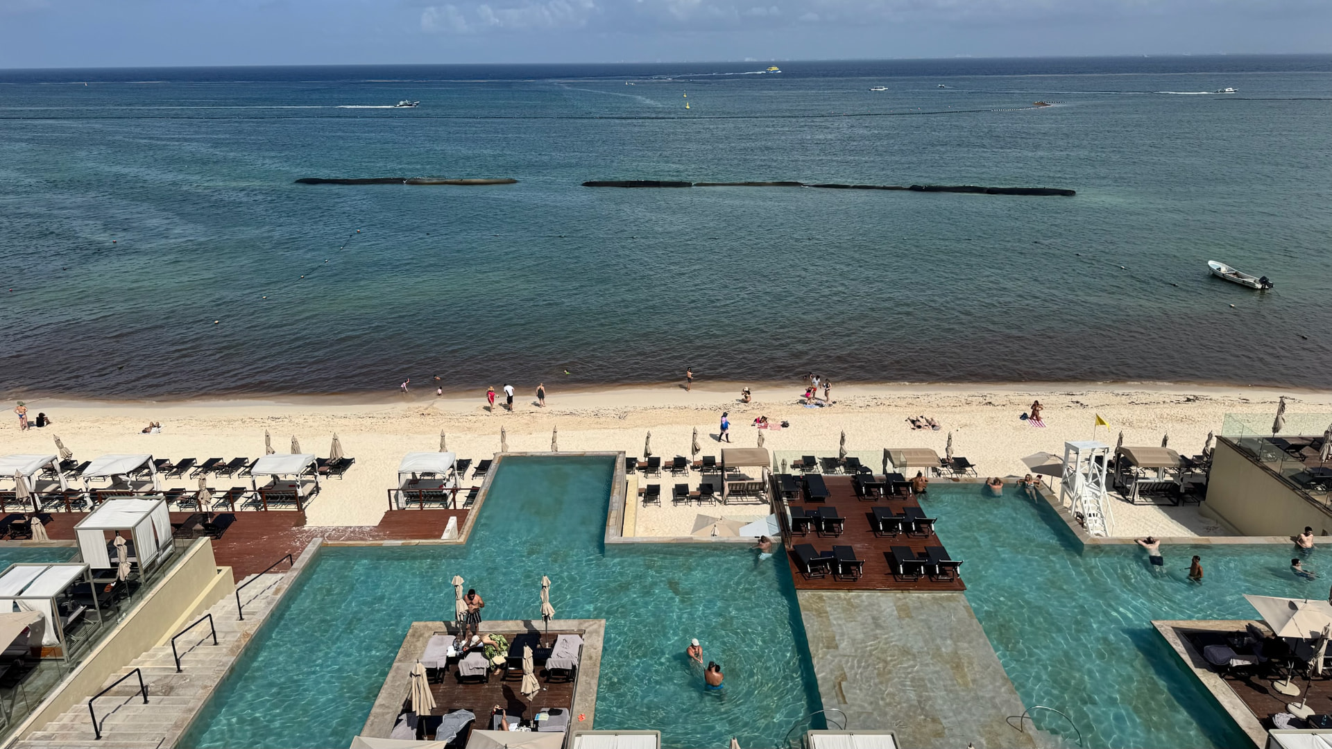 Resort pools meeting the beach and Caribbean in Playa del Carmen