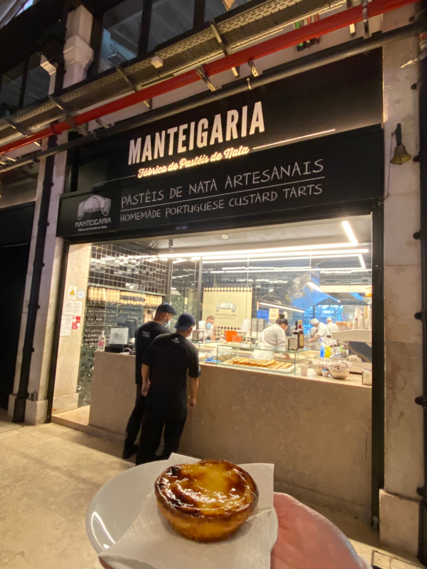 A pastry held up outside the Manteigaria bakery