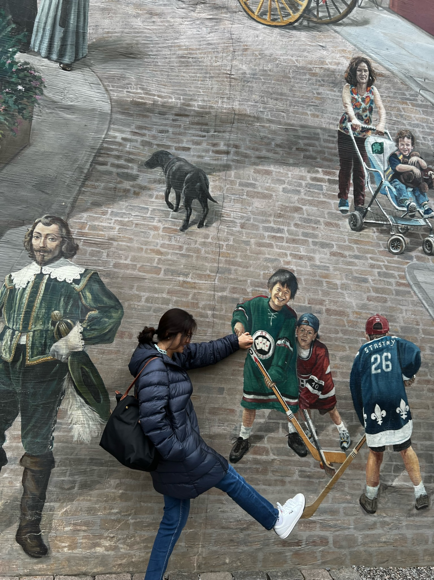 Woman playfully posing with a hockey player painted on the mural
