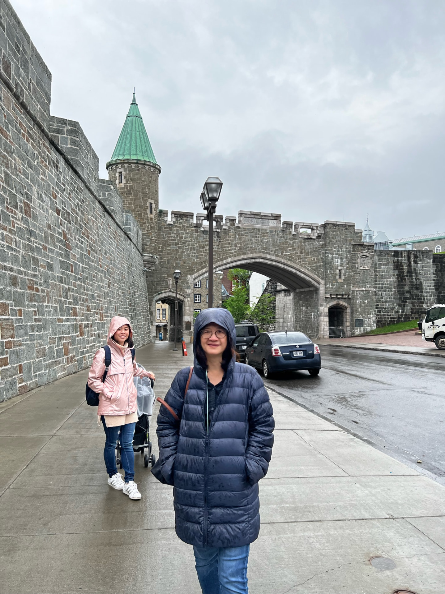 Two women walking near the Porte Saint-Jean in the rain