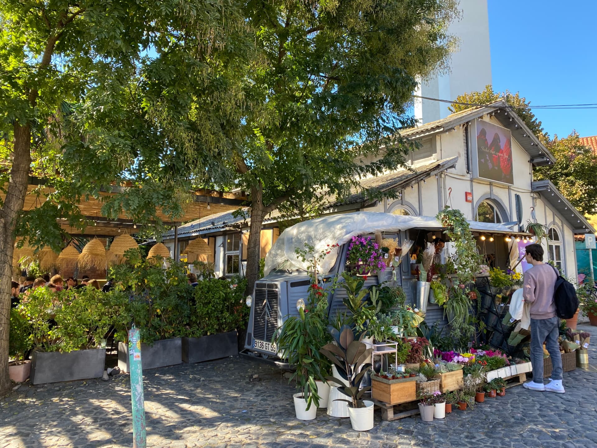 A flower shop built into a vintage van parked beneath trees