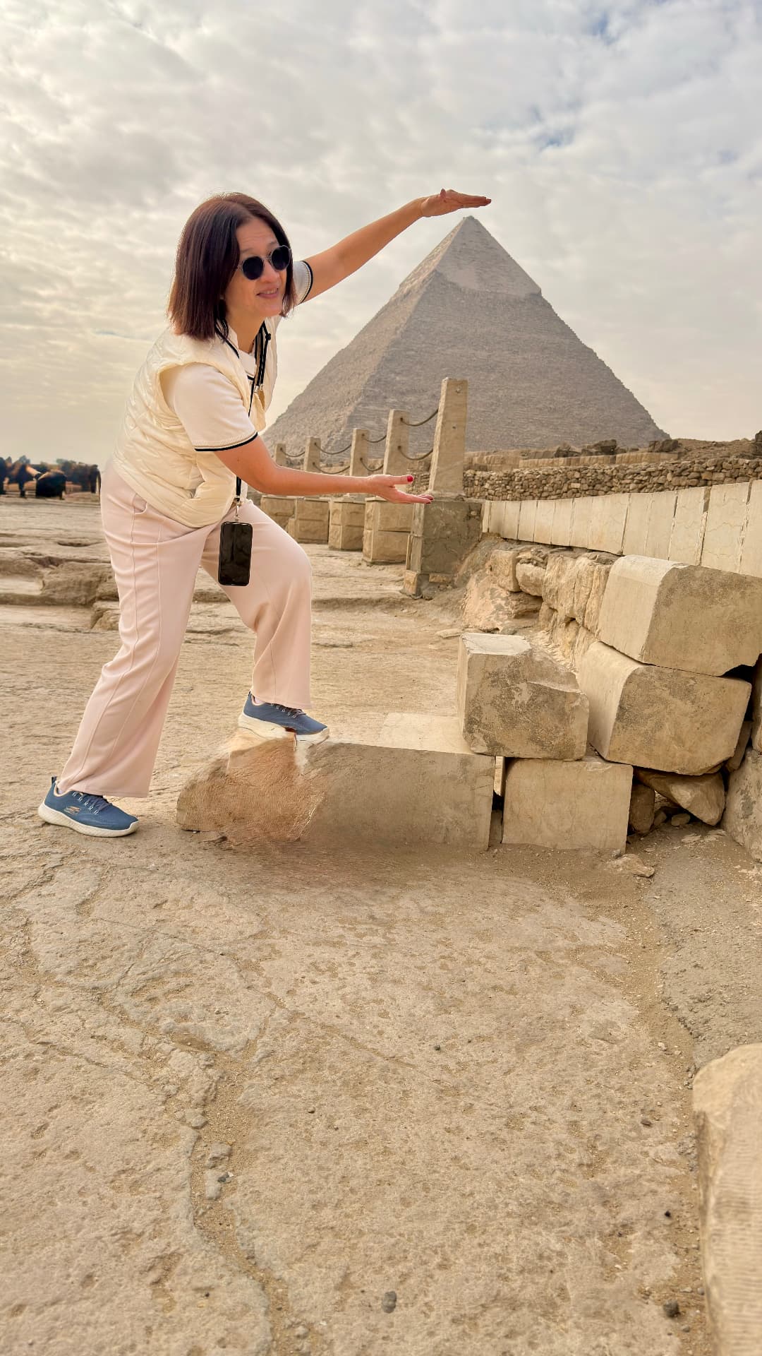 Becky posing with her hand aligned to the tip of the pyramid of Khafre behind her