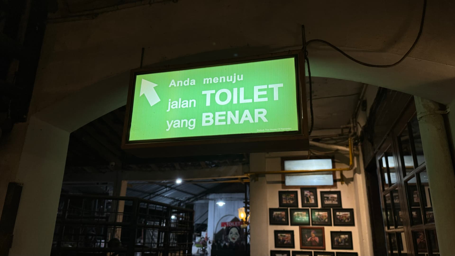 Green direction sign inside the House of Raminten