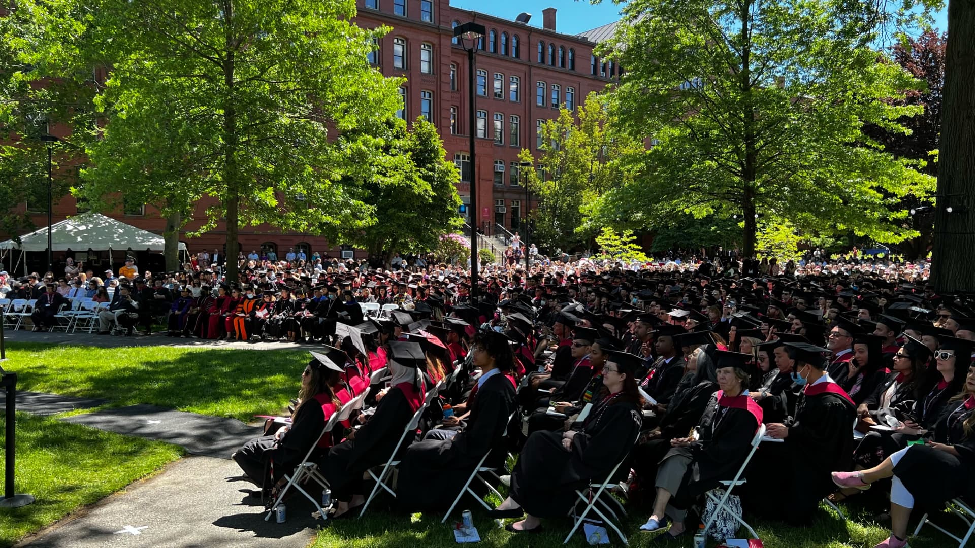 The commencement crowd filling the lawn before a red-brick Harvard building