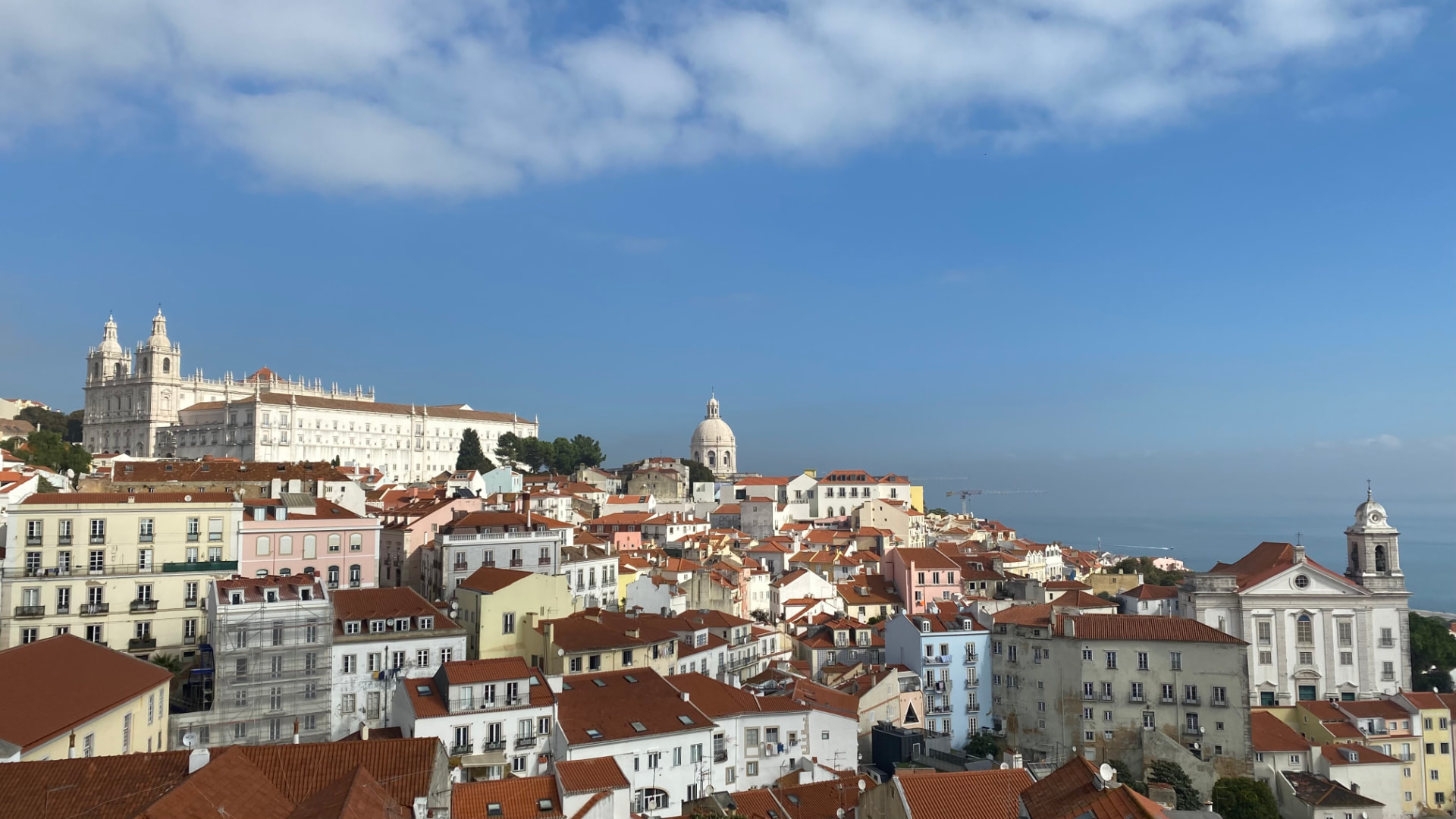 White buildings with terracotta roofs climbing a Lisbon hillside