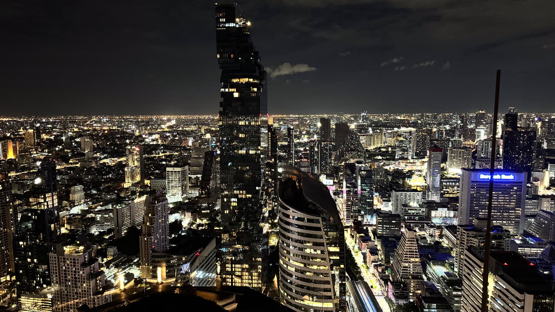 Bangkok skyline glowing at night from a rooftop