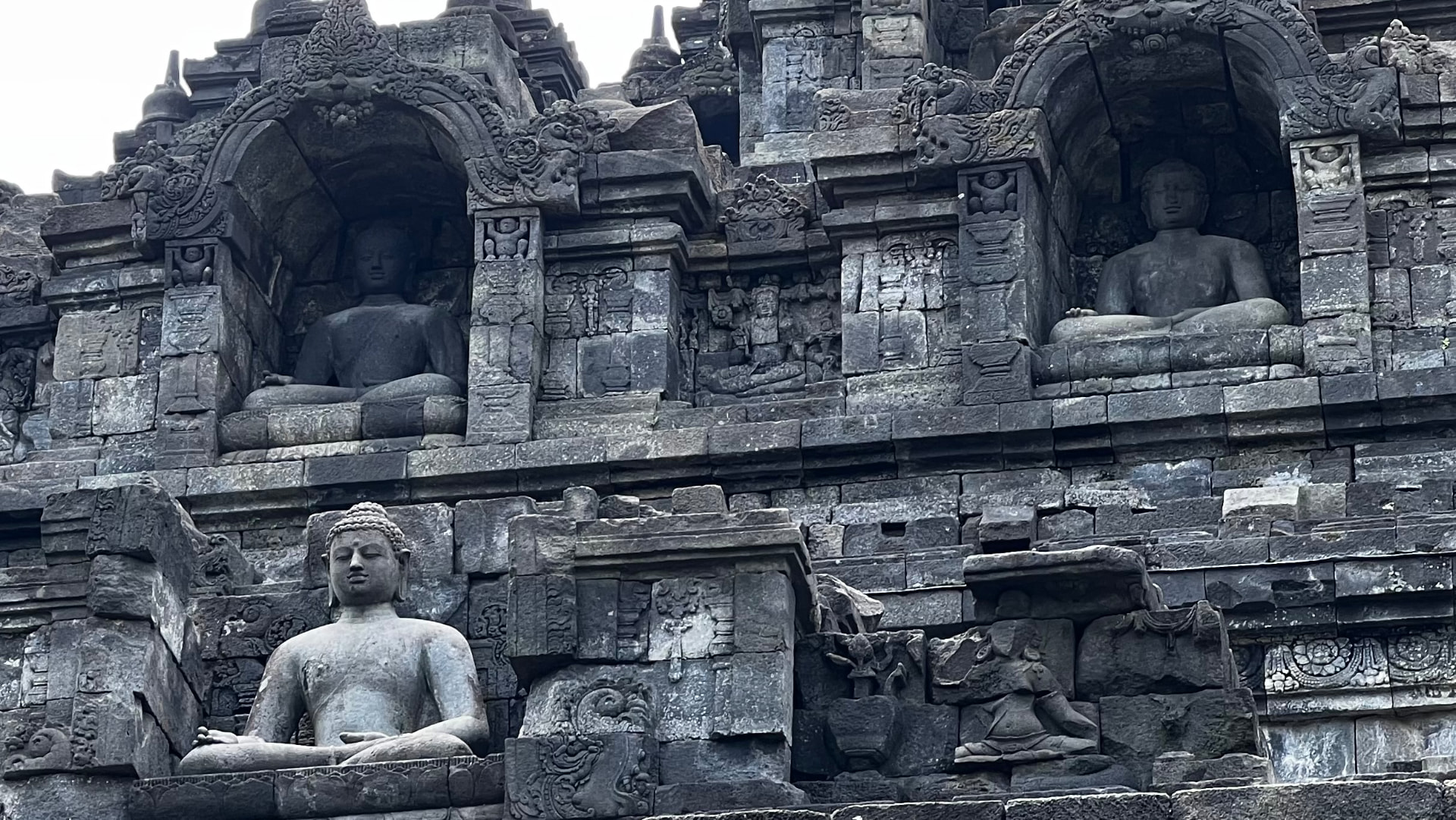 Buddha figures seated in carved niches along the temple wall