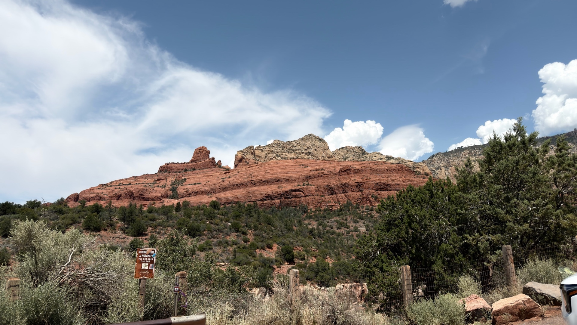 The same red rock ridge seen from the roadside fence