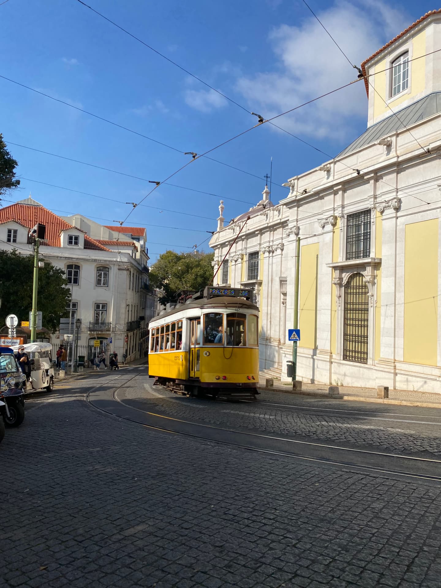A yellow tram climbing a narrow cobbled street