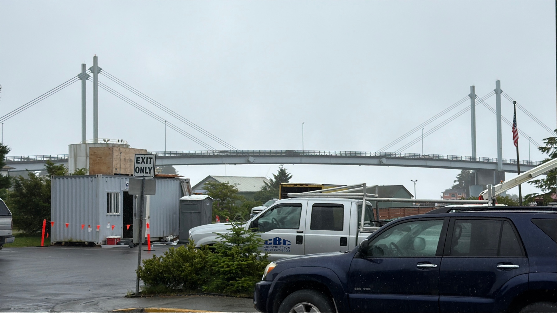 The cable-stayed John O'Connell Bridge arching over the channel in Sitka, seen from a car park on a grey wet day