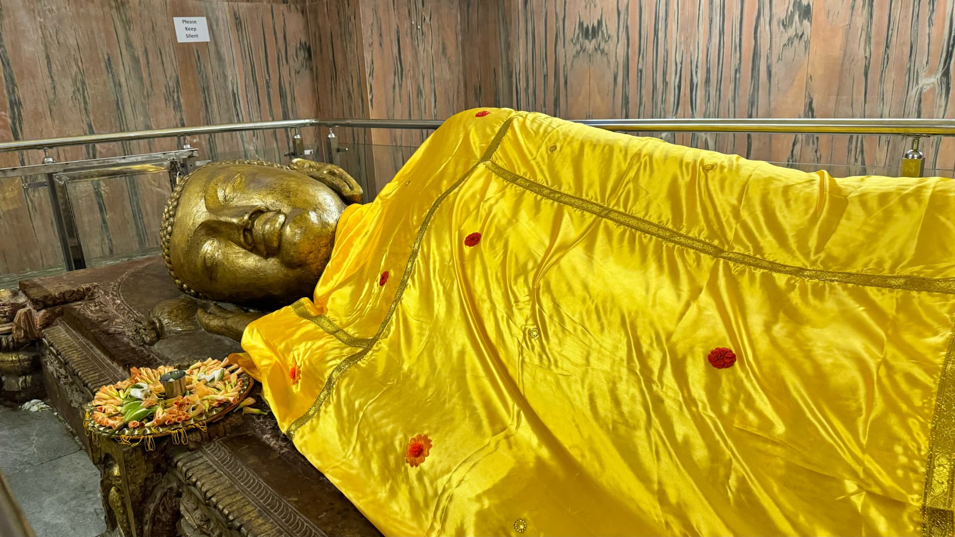 A closer view of the reclining Buddha’s face and yellow robe. — Kushinagar, Uttar Pradesh, India.
