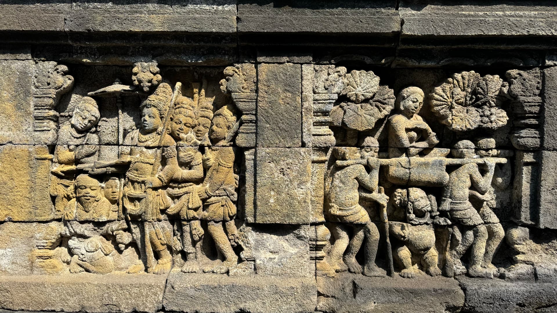 Sunlit carved figures on the temple wall