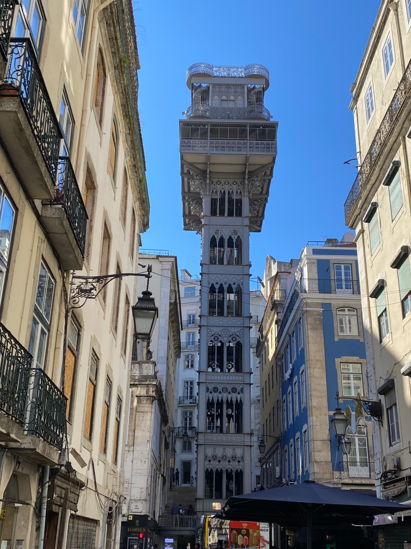 The iron lattice of the Santa Justa Lift rising between buildings