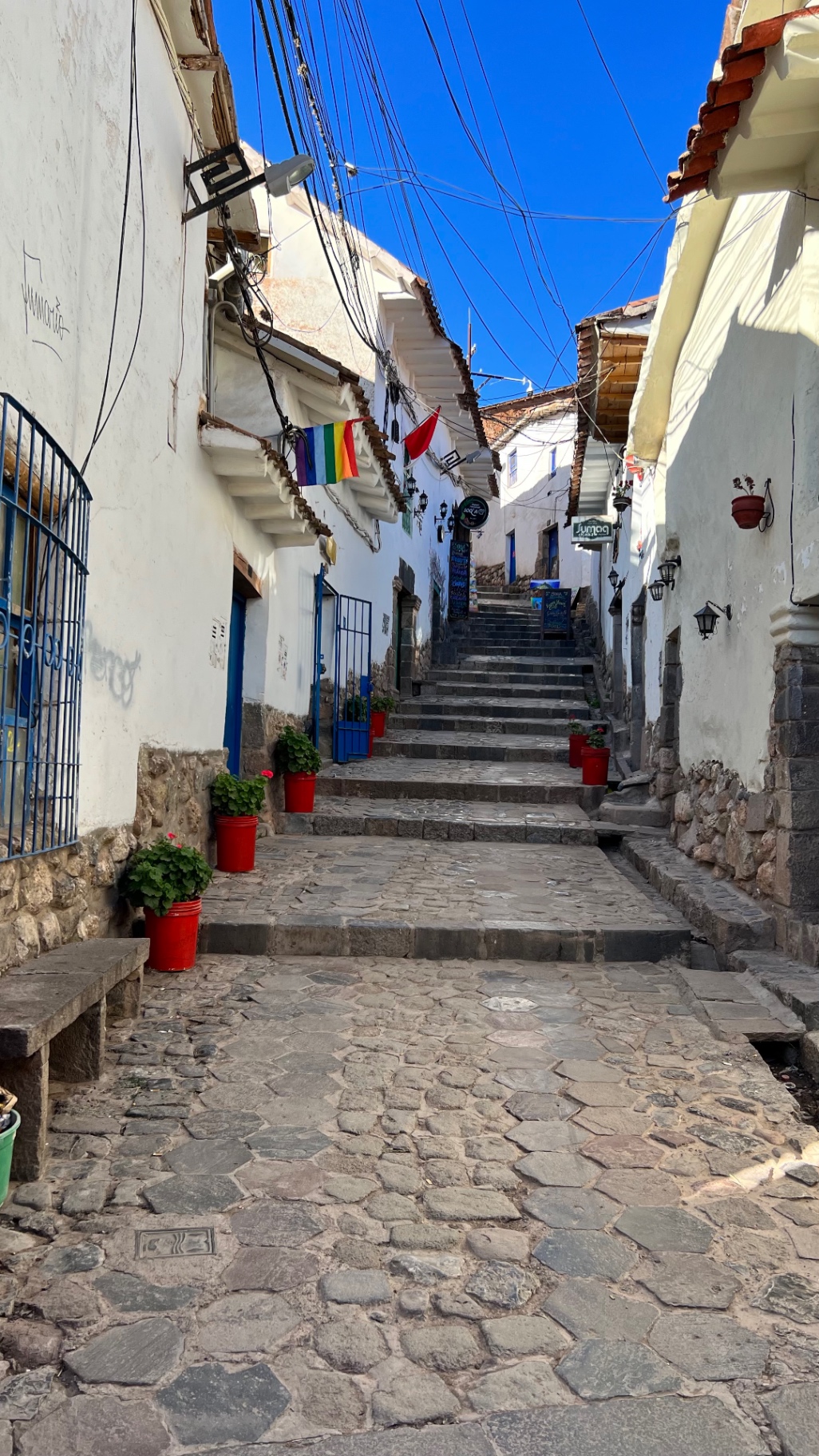 Steep cobbled lane lined with whitewashed buildings in Cusco