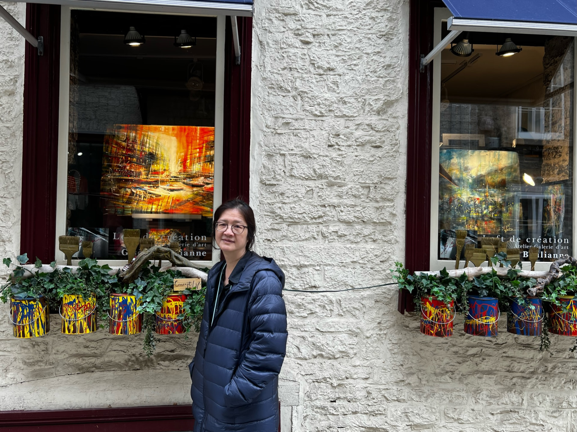 Woman standing outside an art gallery with colorful paintings in the windows