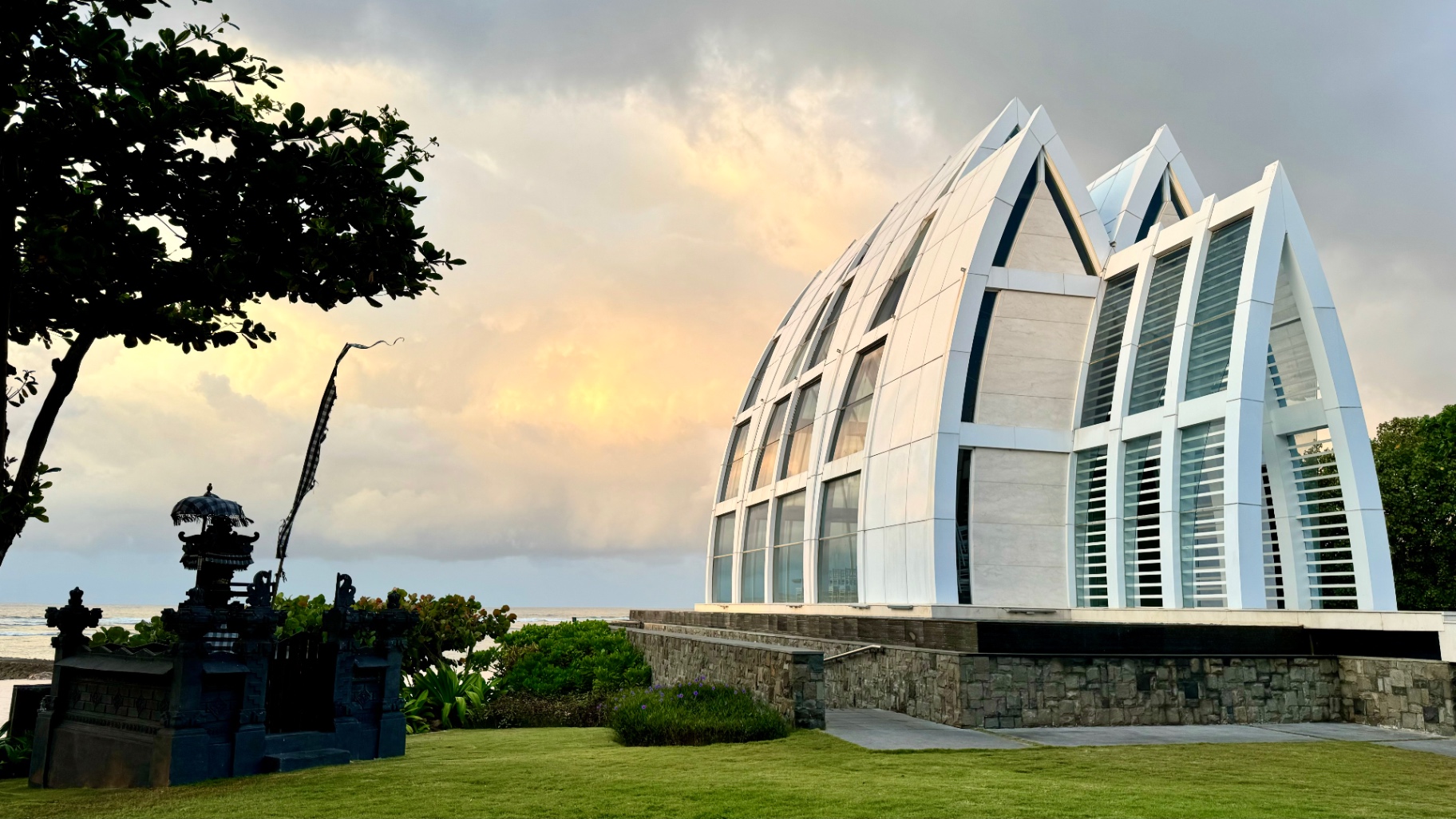 White oceanfront chapel beneath a glowing evening sky