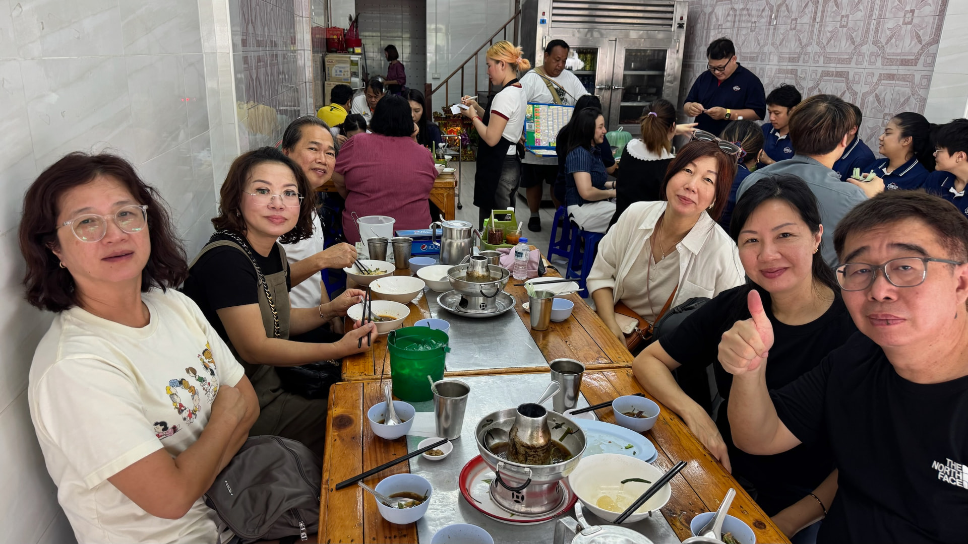 Friends around a busy restaurant table after a shared meal