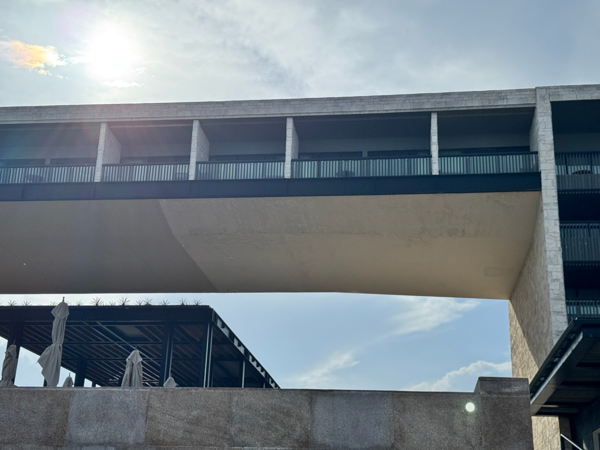 Sculptural bridge spanning a modern resort courtyard